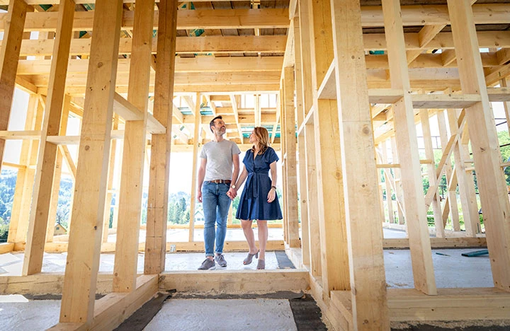 A couple walking around a house being built