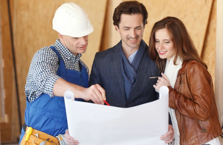 family looking Over blueprints with a construction foreman