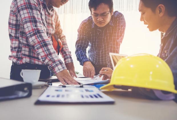 Team of construction workers looking over some plans