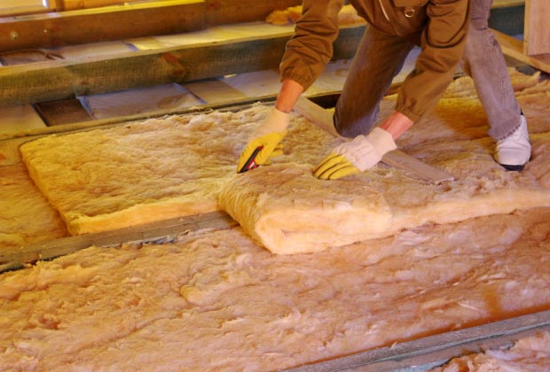 Construction worker laying down insulation.