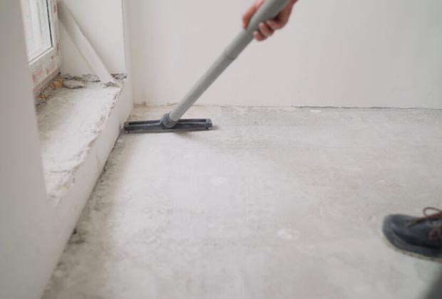 Vacuuming a corner of room