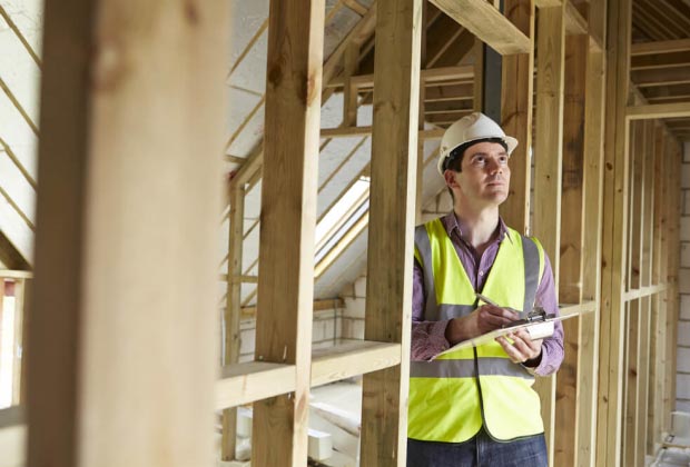 home inspector holding a clipboard looking at the ceiling