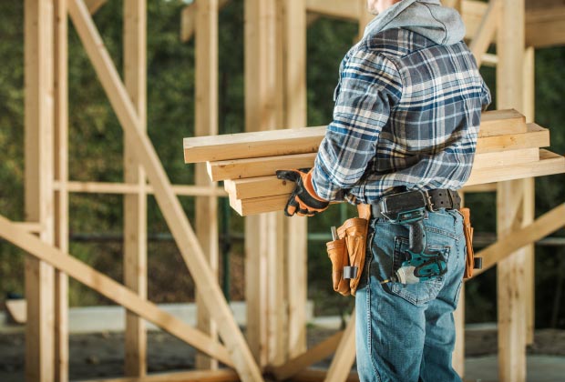 Construction worker holding Lumber