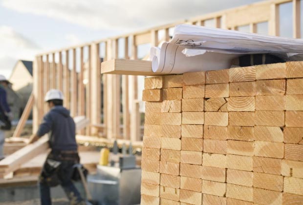 Photo of a construction site with blueprints on top of a pile of wood