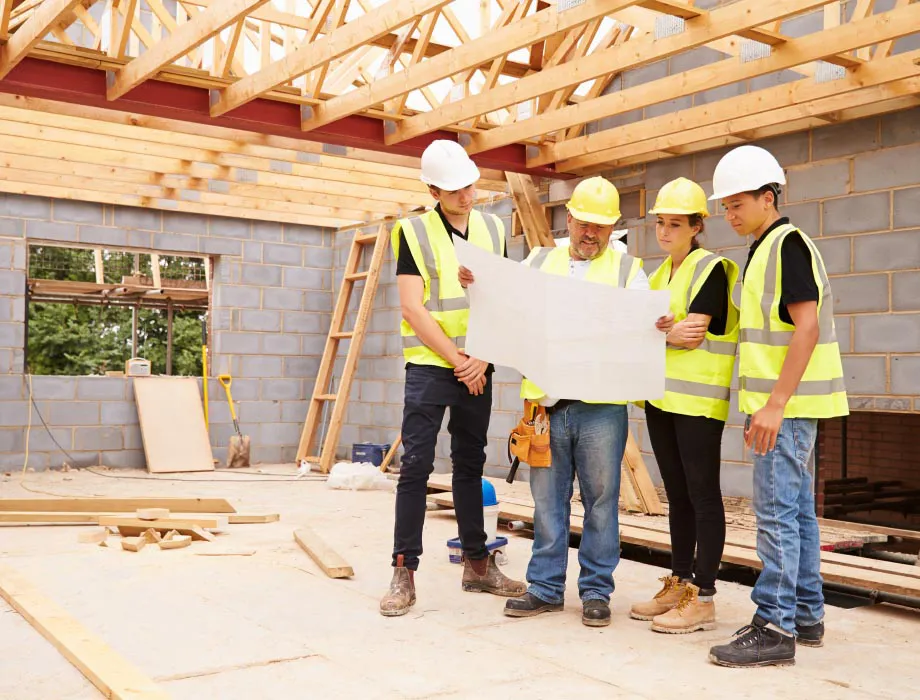 Construction workers holding up blueprints