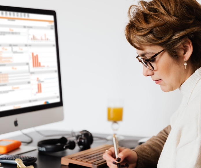 SupplyPro GM blurred desktop screen with woman writing at desk
