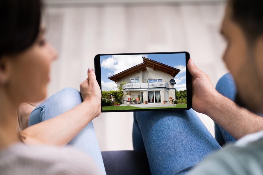 couple holding a tablet showing a home