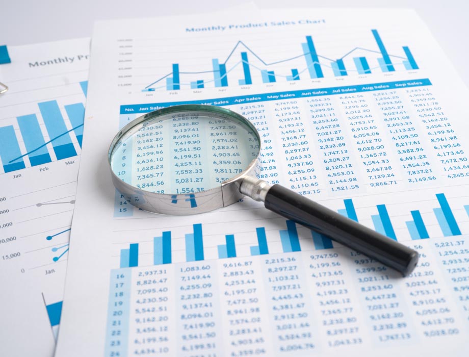 Magnifying glass over a monthly product sales chart