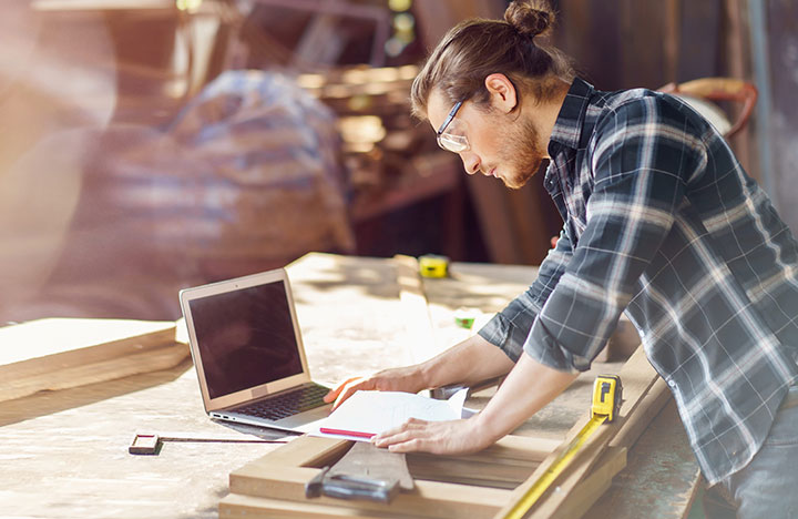 A person working on a laptop at a construction yard