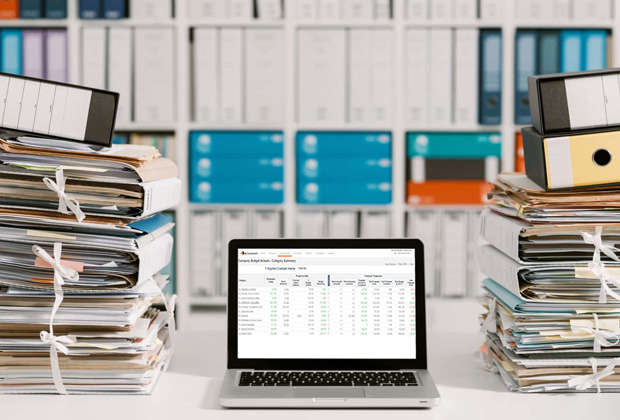Laptop displaying Hyphen BuilderGM software with paperwork in the background