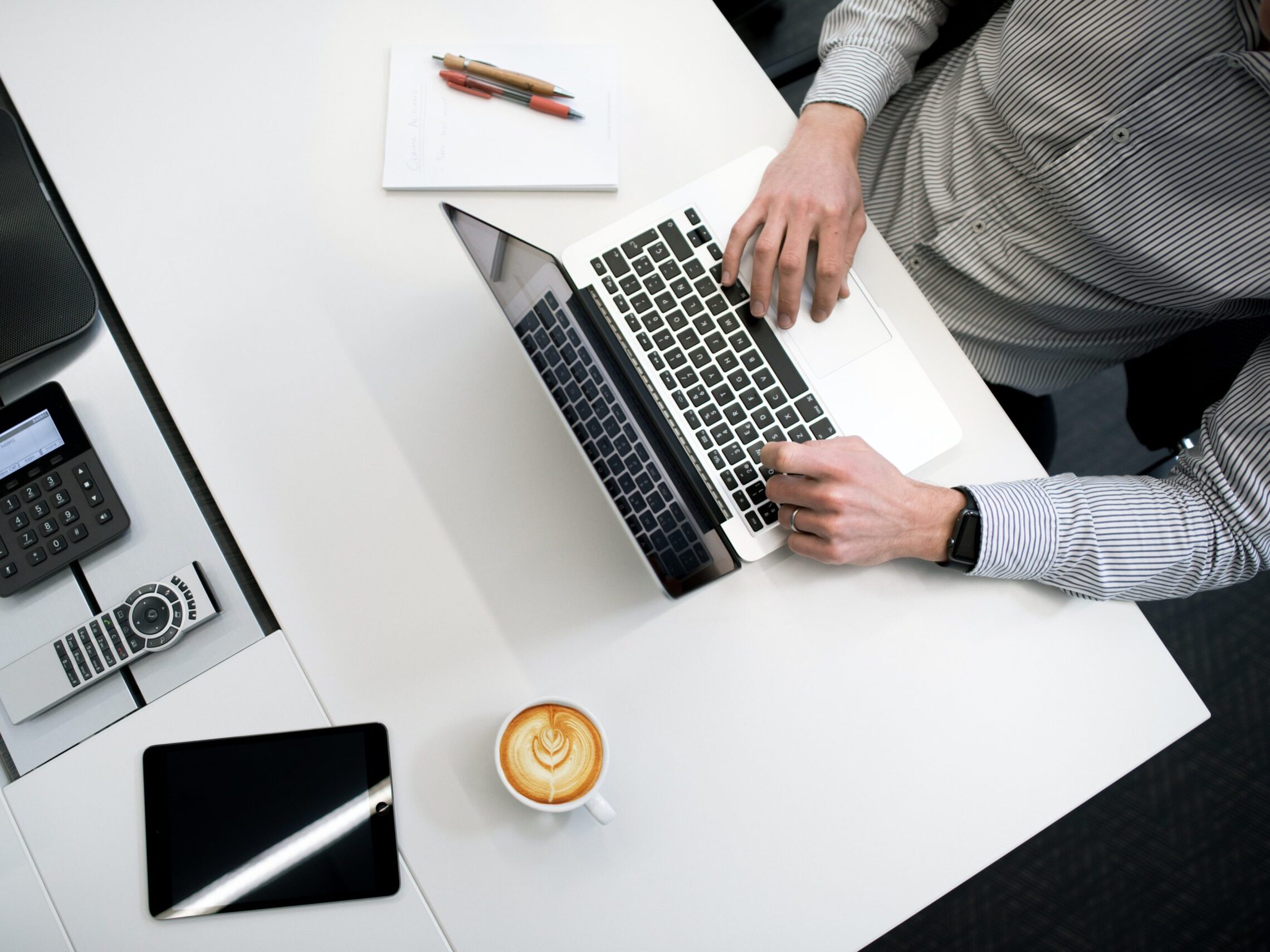 Man using laptop and iPad at a desk