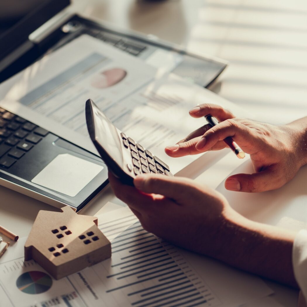 hands typing on calculator in a residential construction management office setting