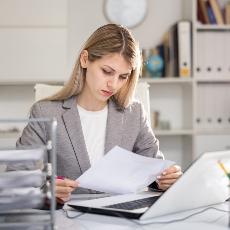 Accounting professional reviewing paperwork at an office desk