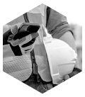 Construction worker holding a hard hat while looking at a phone