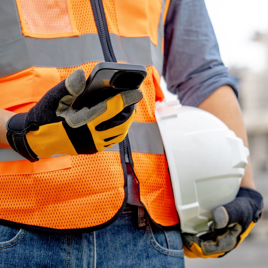 Construction worker looking at phone