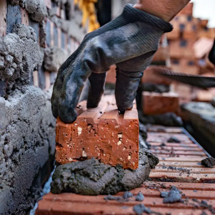 Mason laying a brick